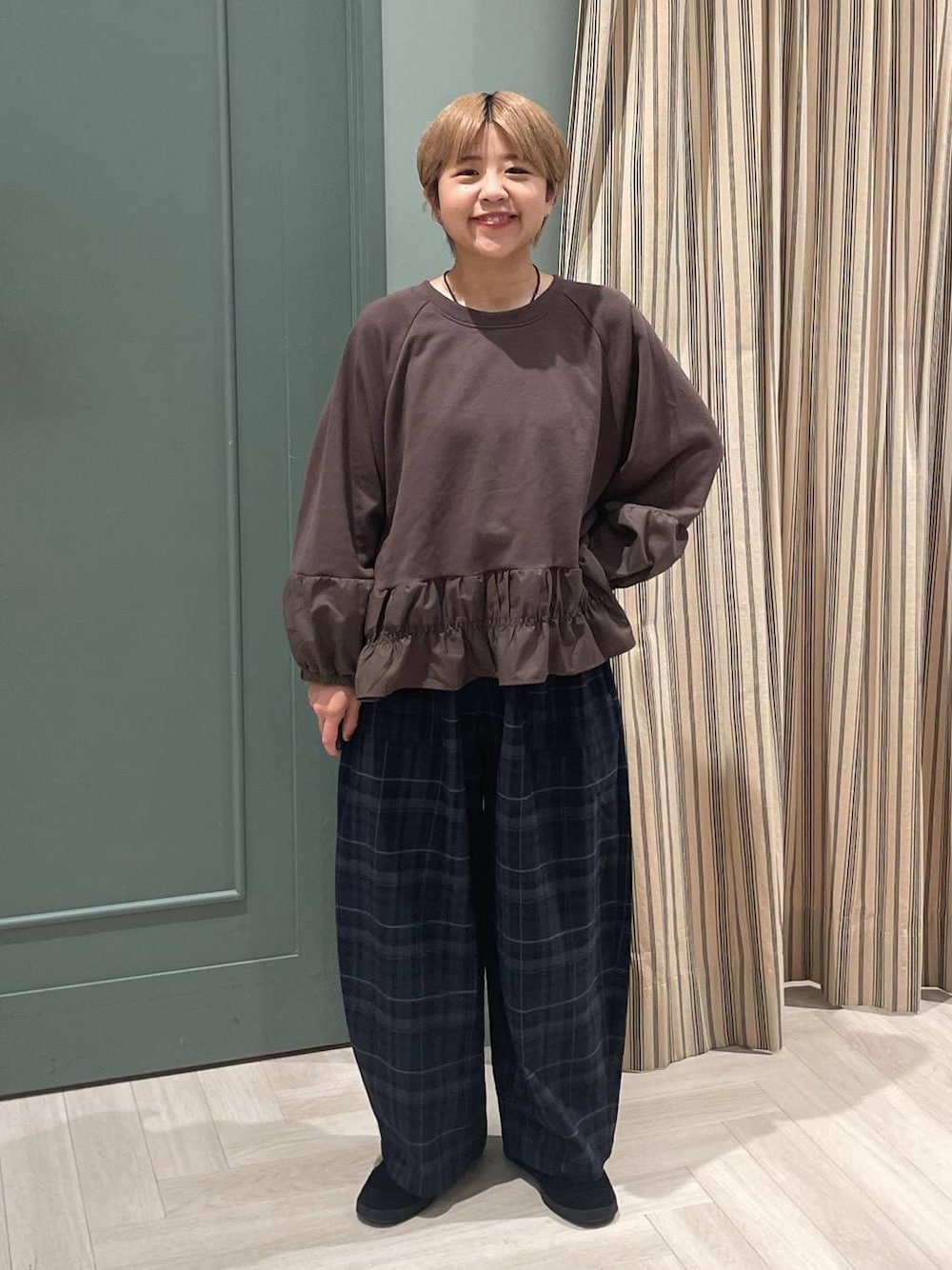 グレー系のその他パンツ、ブラック系のスニーカーを着用したレディースの秋コーディネートの1枚目の写真