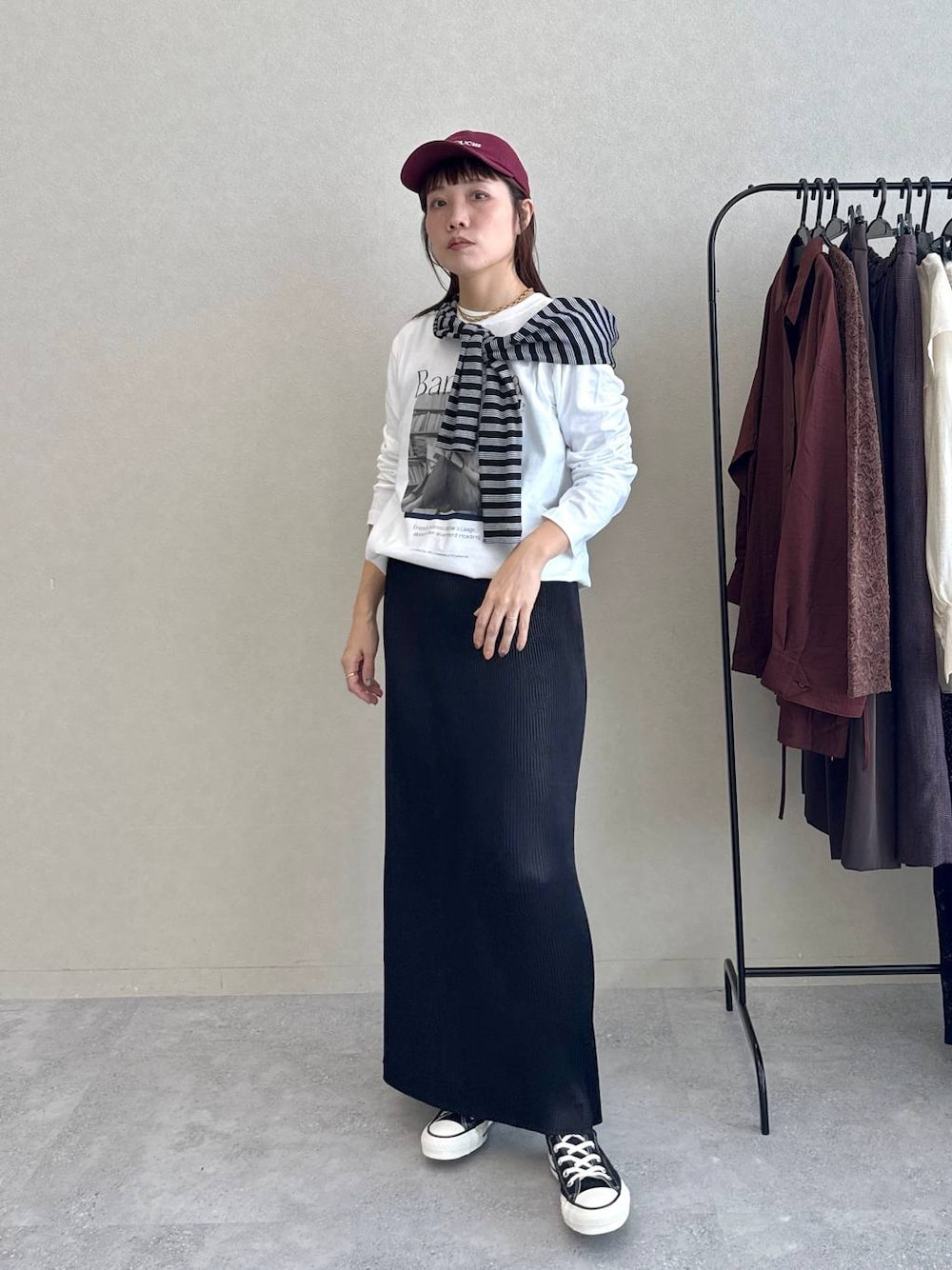 ブラック系のスカート、ホワイト系のTシャツ/カットソー、ブラック系のバレッタ/ヘアクリップを着用したレディースの秋コーディネートの1枚目の写真