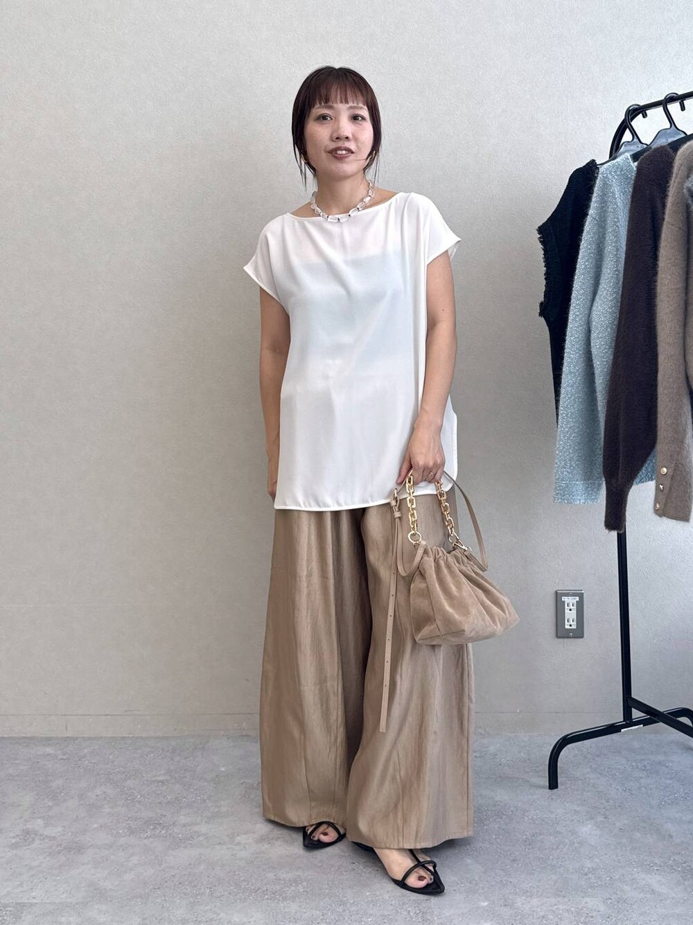 ブラック系のサンダル、ベージュ系のその他パンツ、ホワイト系のTシャツ/カットソーを着用したレディースの夏コーディネートの1枚目の写真