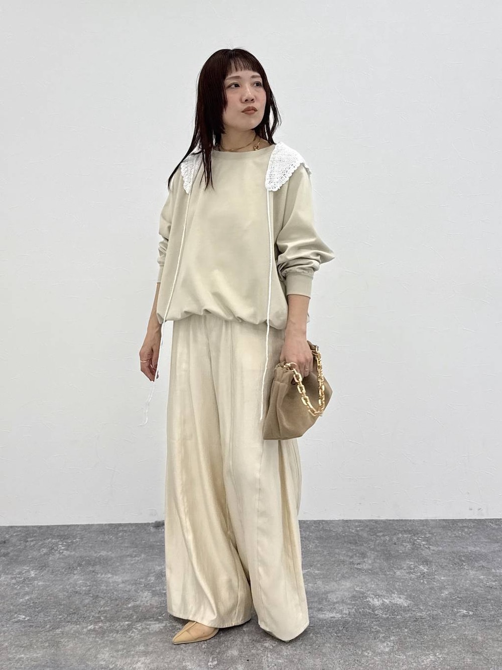 ホワイト系のその他パンツ、ベージュ系のショルダーバッグ、ホワイト系のストール/ショールを着用したレディースの春コーディネートの1枚目の写真