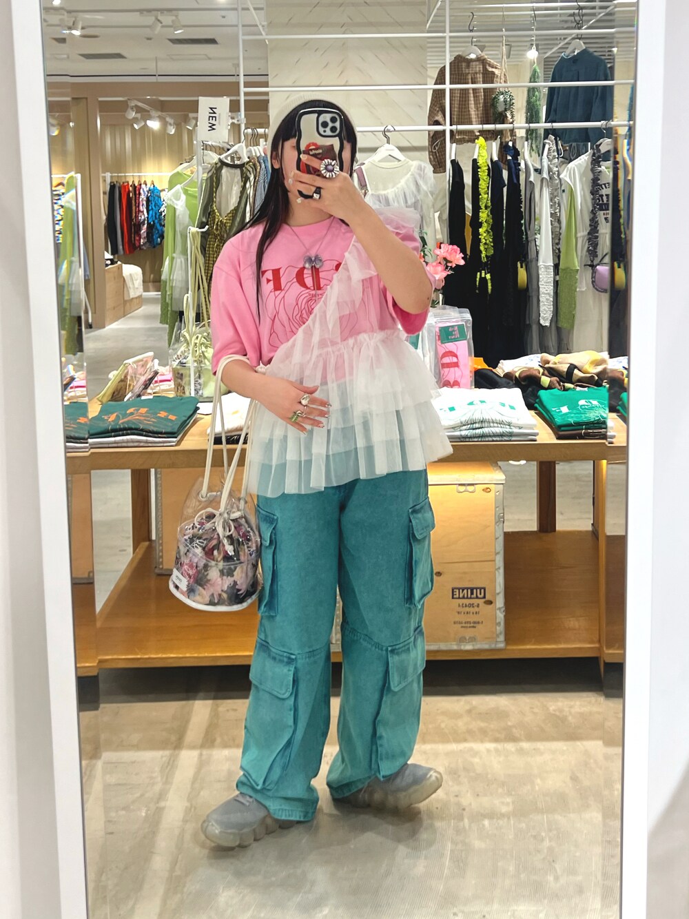 ホワイト系のベスト、ピンク系のTシャツ/カットソー、グリーン系のデニムパンツを着用したレディースの春コーディネートの1枚目の写真