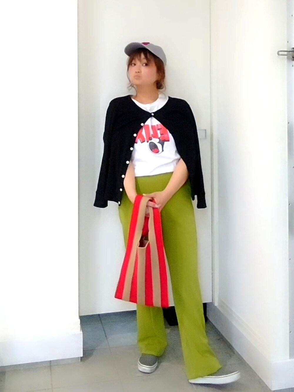 グリーン系のその他パンツ、レッド系のトートバッグ、ブラック系のカーディガン/ボレロを着用したレディースの春コーディネートの3枚目の写真