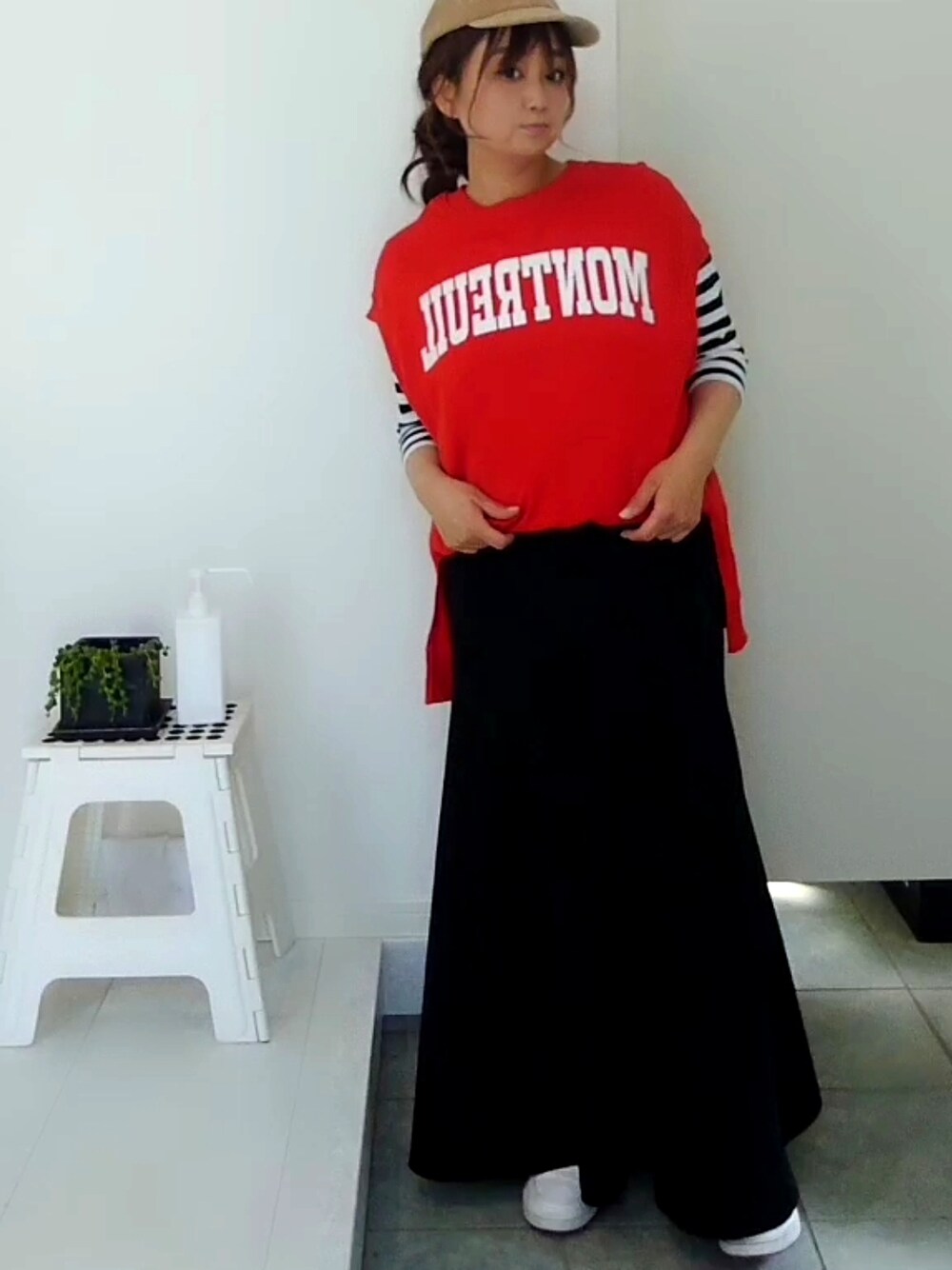 オレンジ系のスウェット、ブラック系のスカート、ブラック系のTシャツ/カットソーを着用したレディースの春コーディネートの3枚目の写真