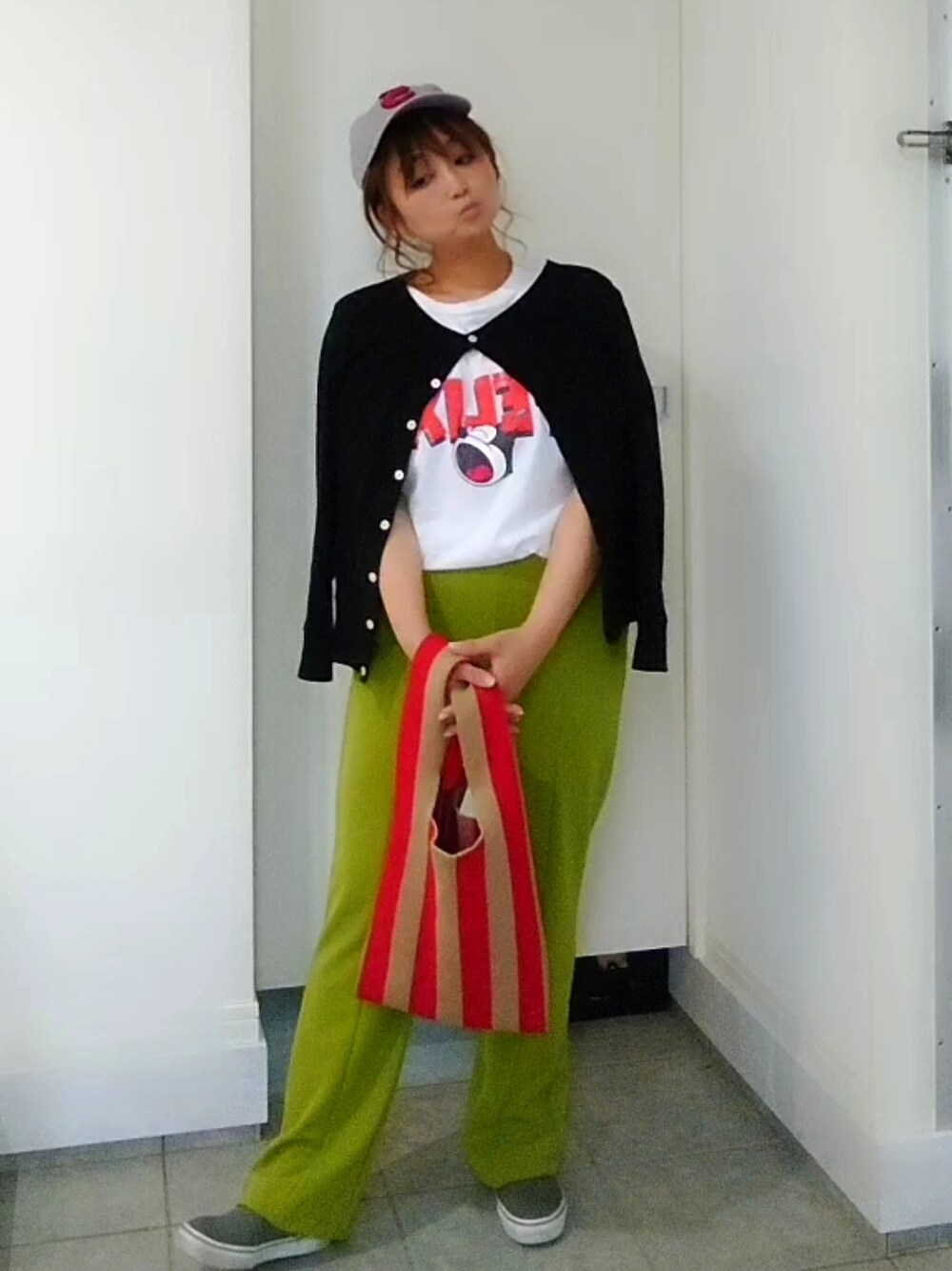 グリーン系のその他パンツ、レッド系のトートバッグ、ブラック系のカーディガン/ボレロを着用したレディースの春コーディネートの2枚目の写真