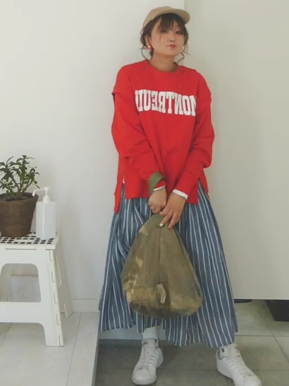 オレンジ系のスウェットを着用したレディースの冬コーディネートの3枚目の写真