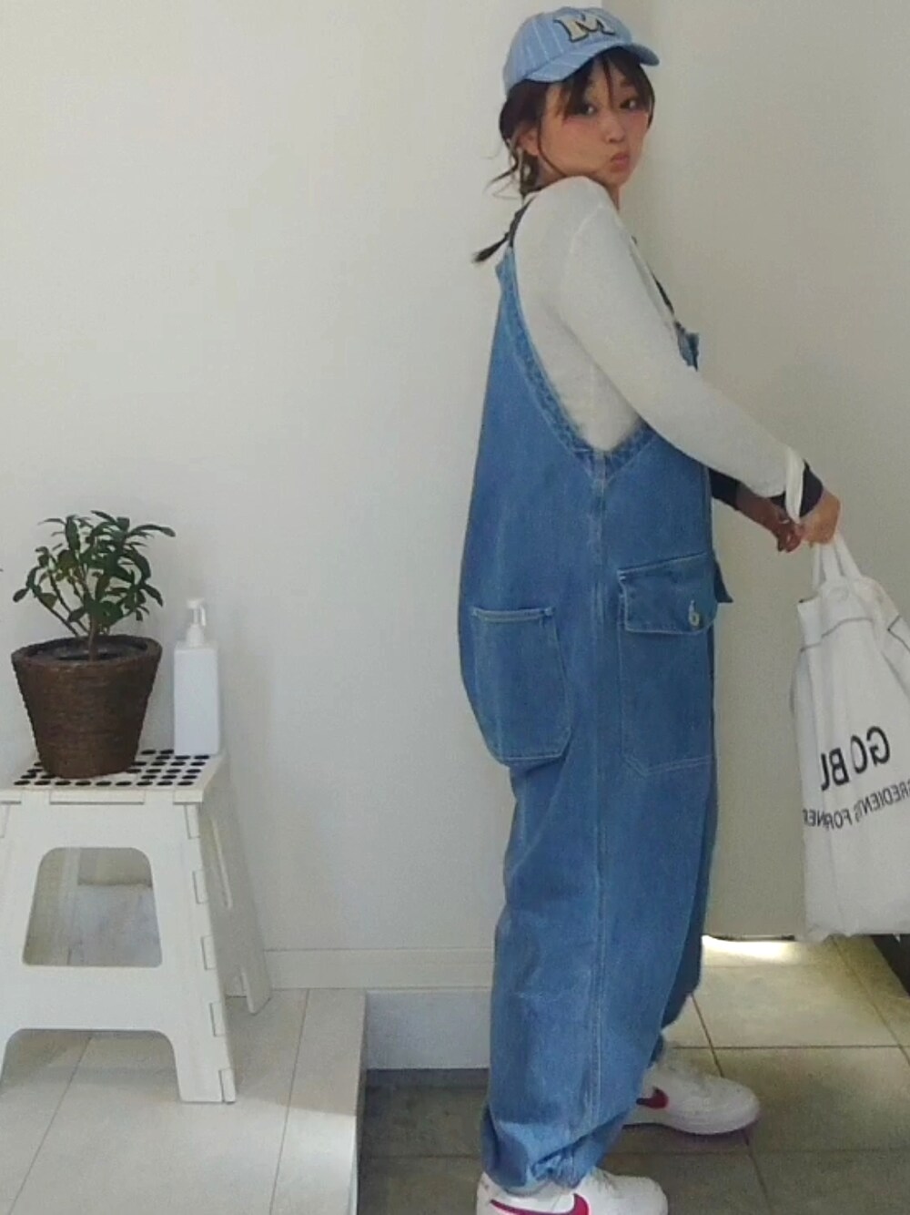 ブルー系のサロペット/オーバーオール、ホワイト系のTシャツ/カットソーを着用したレディースの冬コーディネートの4枚目の写真