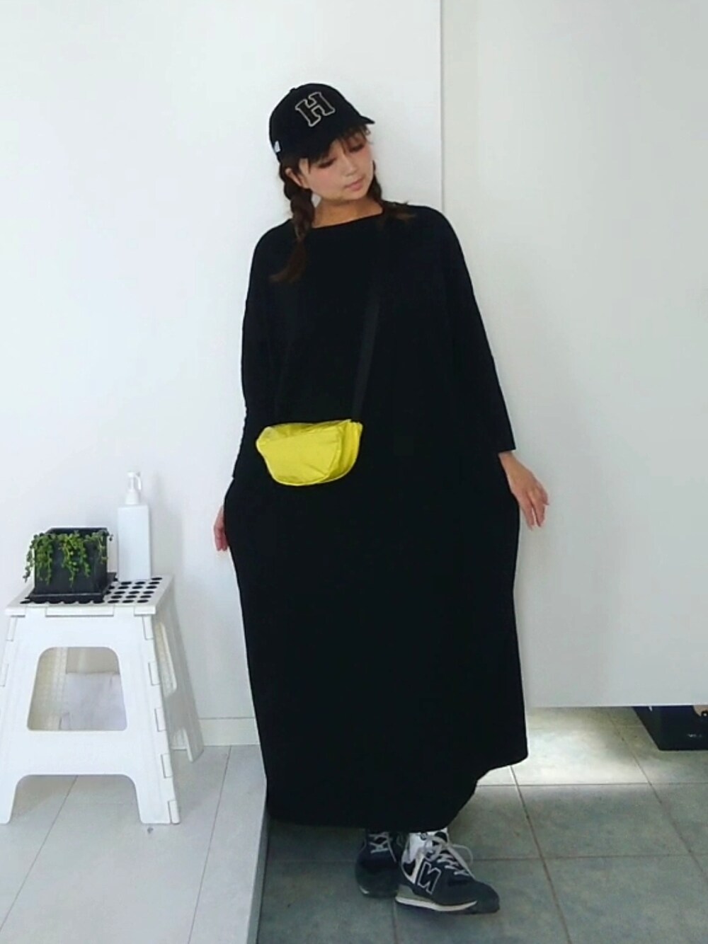 イエロー系のボディバッグ/ウエストポーチ、ブラック系のワンピースを着用したレディースの春コーディネートの2枚目の写真
