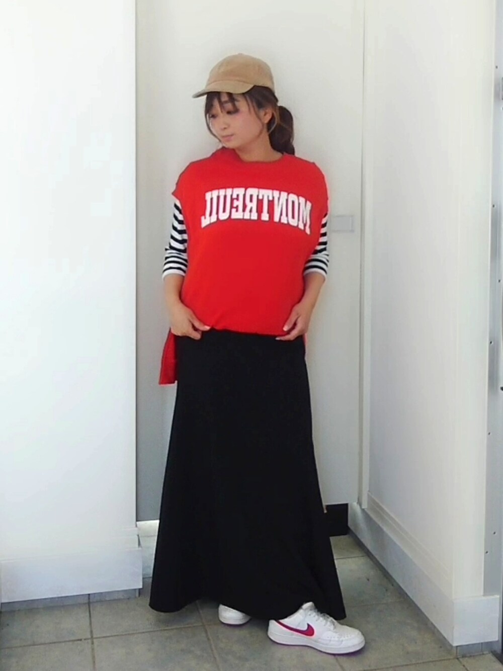 オレンジ系のスウェット、ブラック系のスカート、ブラック系のTシャツ/カットソーを着用したレディースの春コーディネートの2枚目の写真