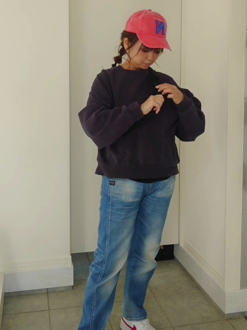 レッド系のスニーカー、ブルー系のデニムパンツ、ブルー系のスウェットを着用したレディースの春コーディネートの3枚目の写真