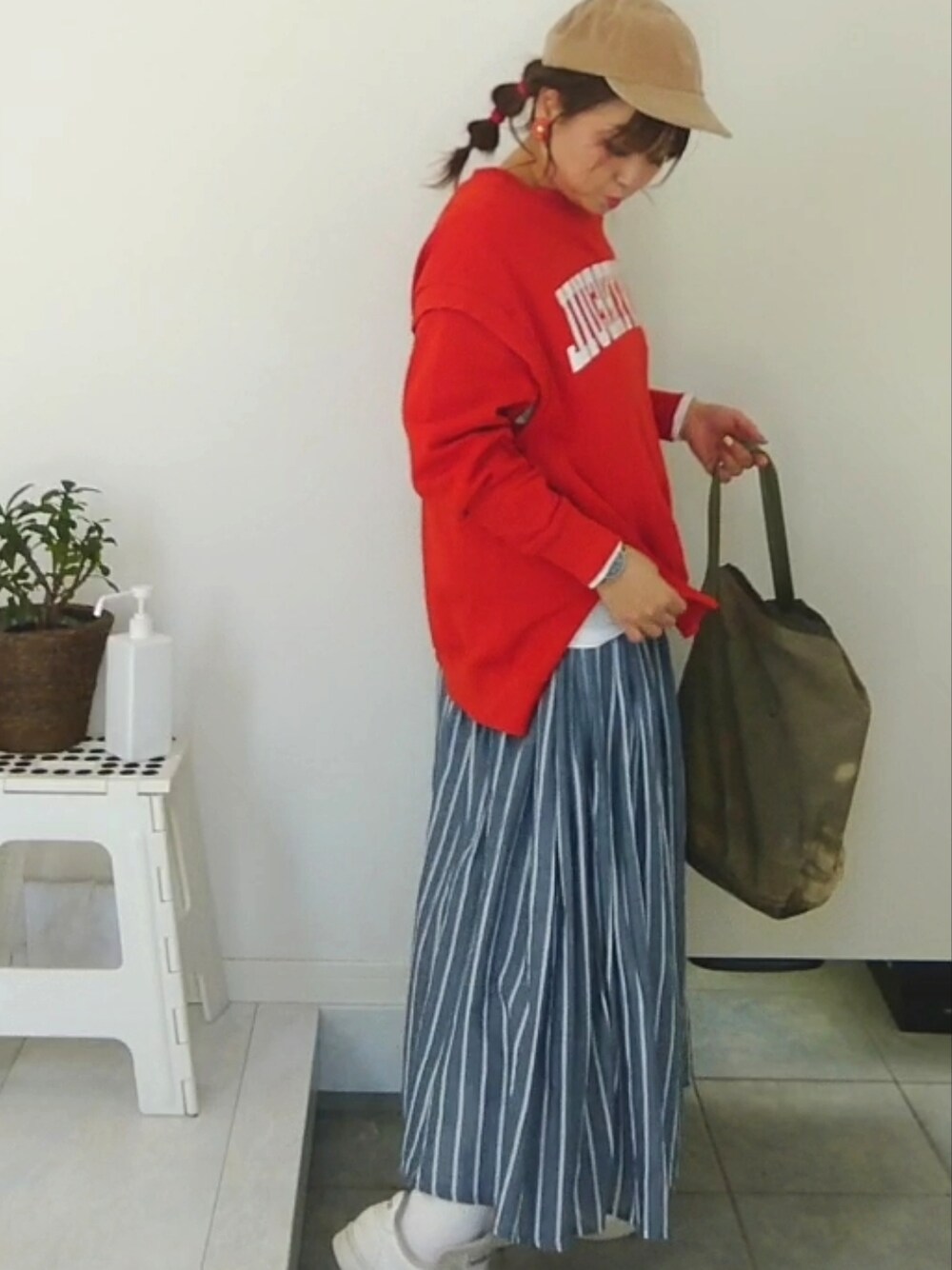 オレンジ系のスウェットを着用したレディースの冬コーディネートの2枚目の写真