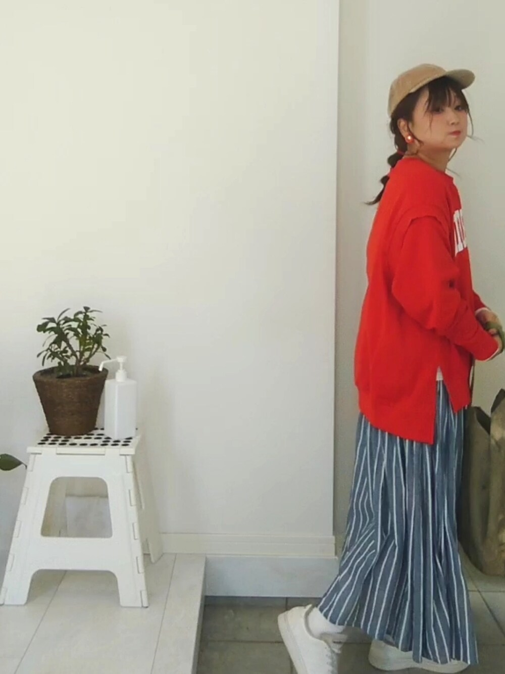 オレンジ系のスウェットを着用したレディースの冬コーディネートの4枚目の写真