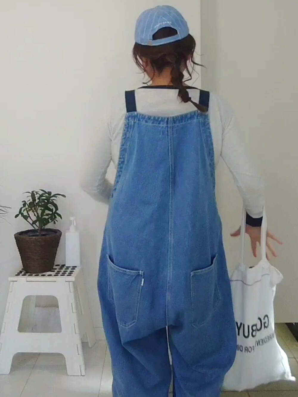 ブルー系のサロペット/オーバーオール、ホワイト系のTシャツ/カットソーを着用したレディースの冬コーディネートの2枚目の写真