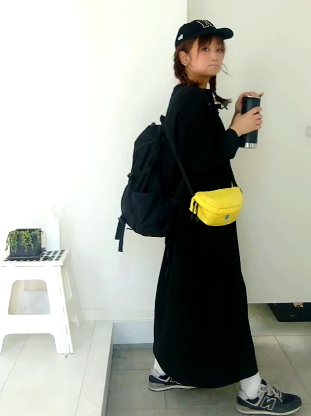 イエロー系のボディバッグ/ウエストポーチ、ブラック系のワンピースを着用したレディースの春コーディネートの3枚目の写真