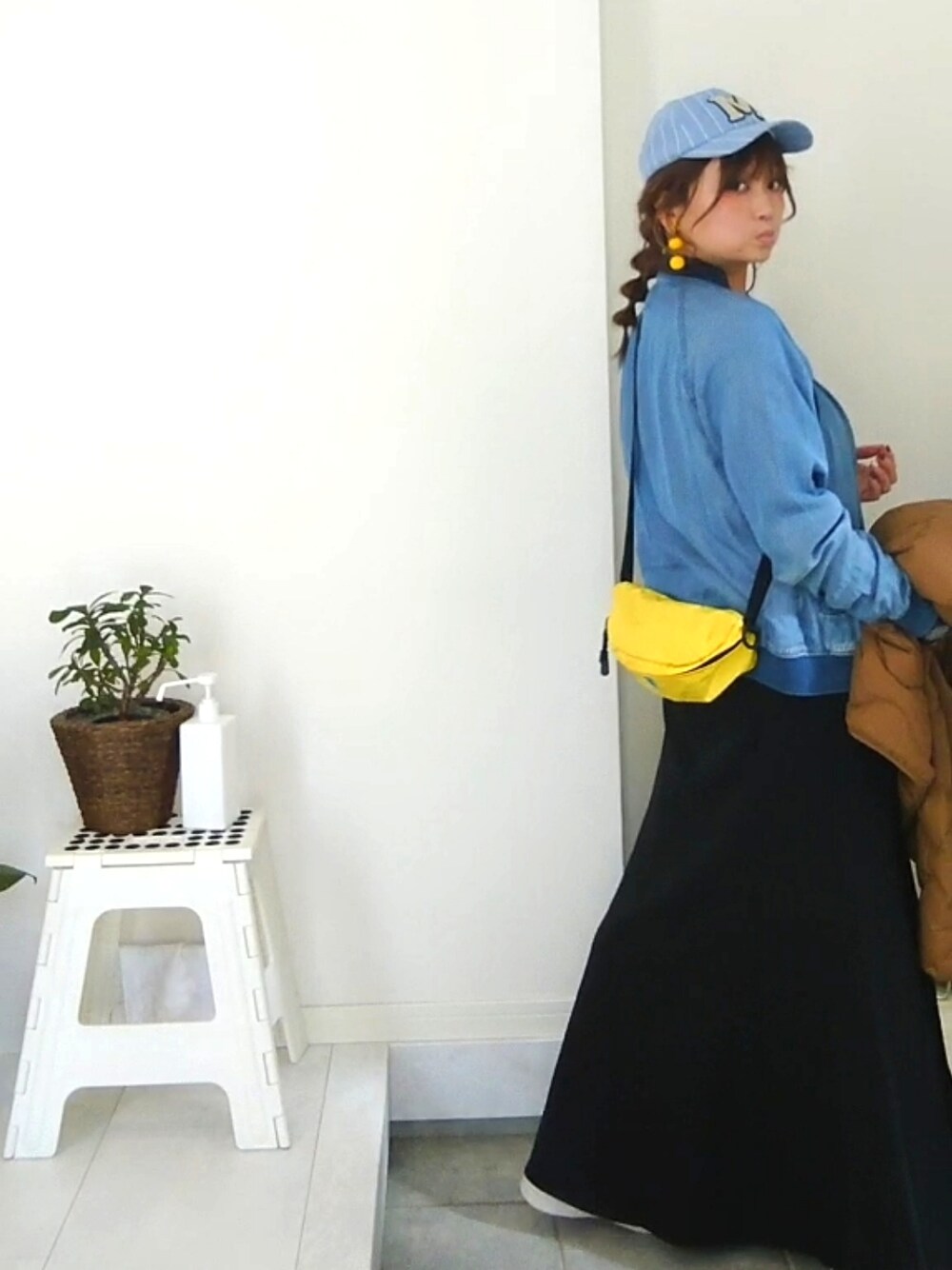 イエロー系のボディバッグ/ウエストポーチを着用したレディースの冬コーディネートの2枚目の写真