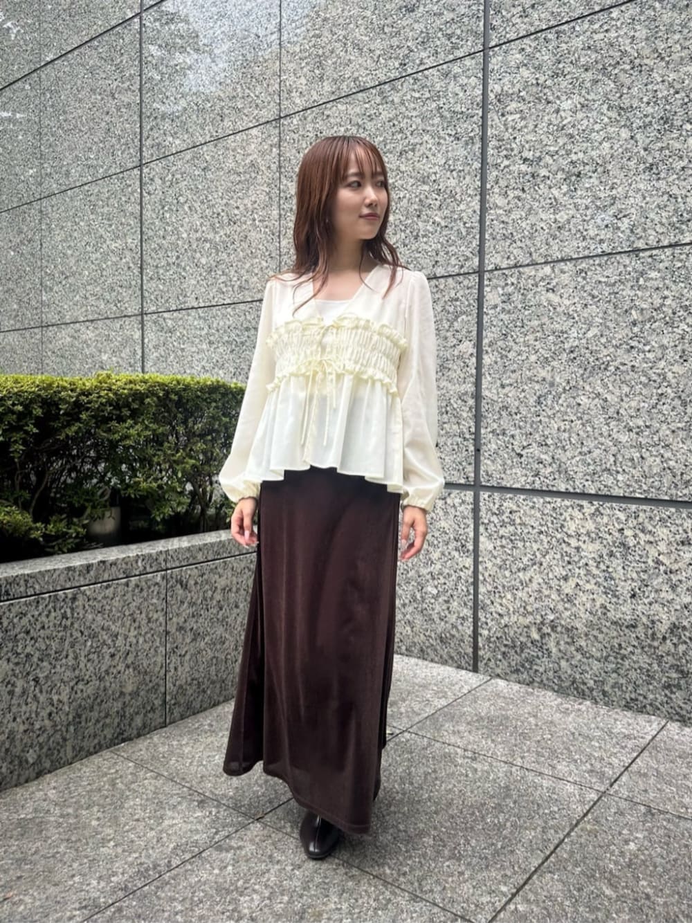 ホワイト系のシャツ/ブラウス、ブラウン系のスカート、ブラウン系のブーツを着用したレディースの秋コーディネートの1枚目の写真