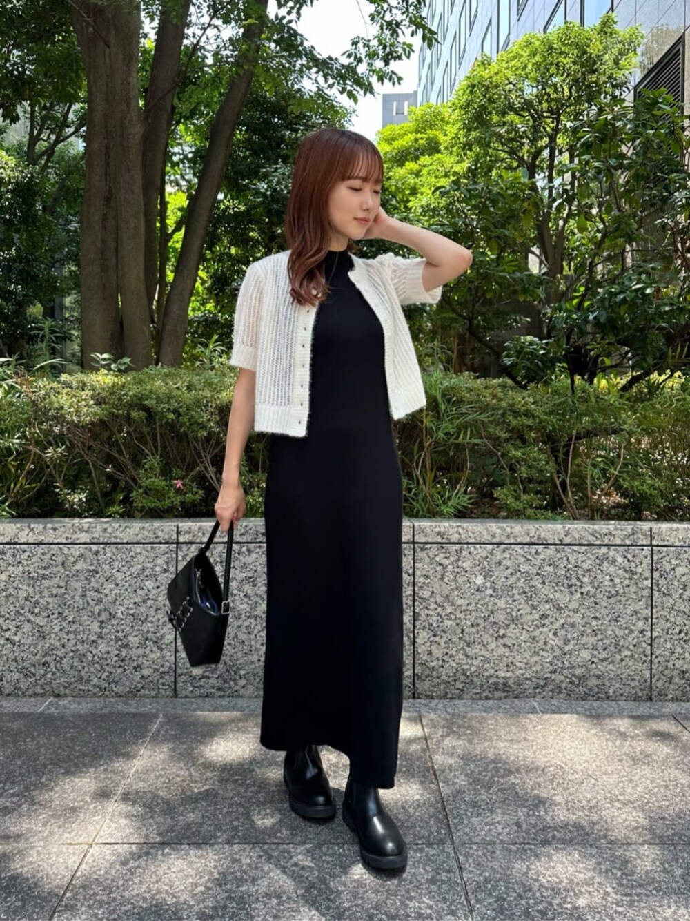 ブラック系のショルダーバッグ、ブラック系のワンピース、ブラック系のブーツを着用したレディースの秋コーディネートの1枚目の写真