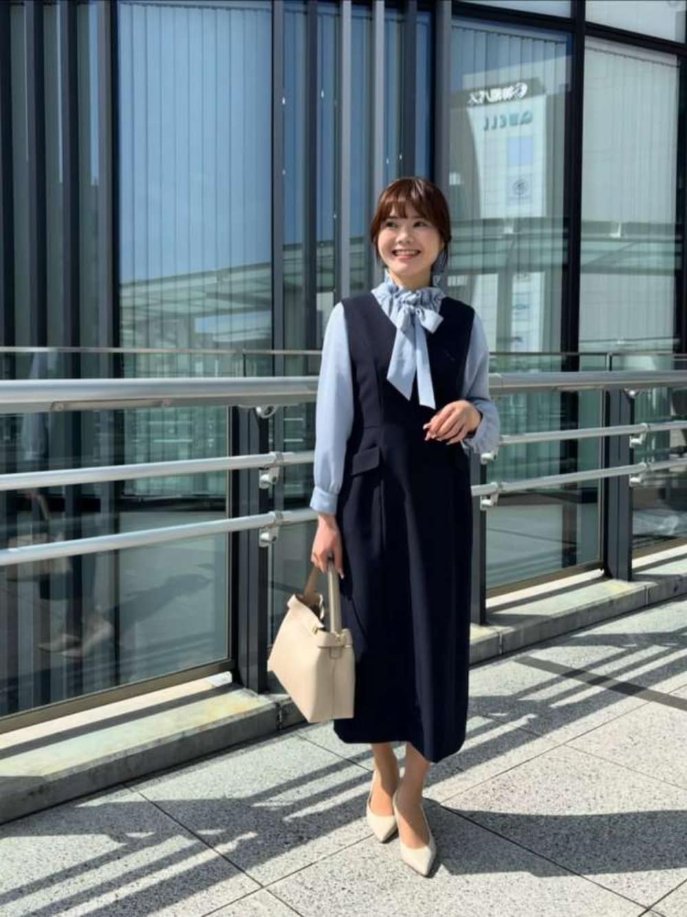 ブルー系のジャンパースカート、ブルー系のシャツ/ブラウスを着用したレディースの春コーディネートの1枚目の写真