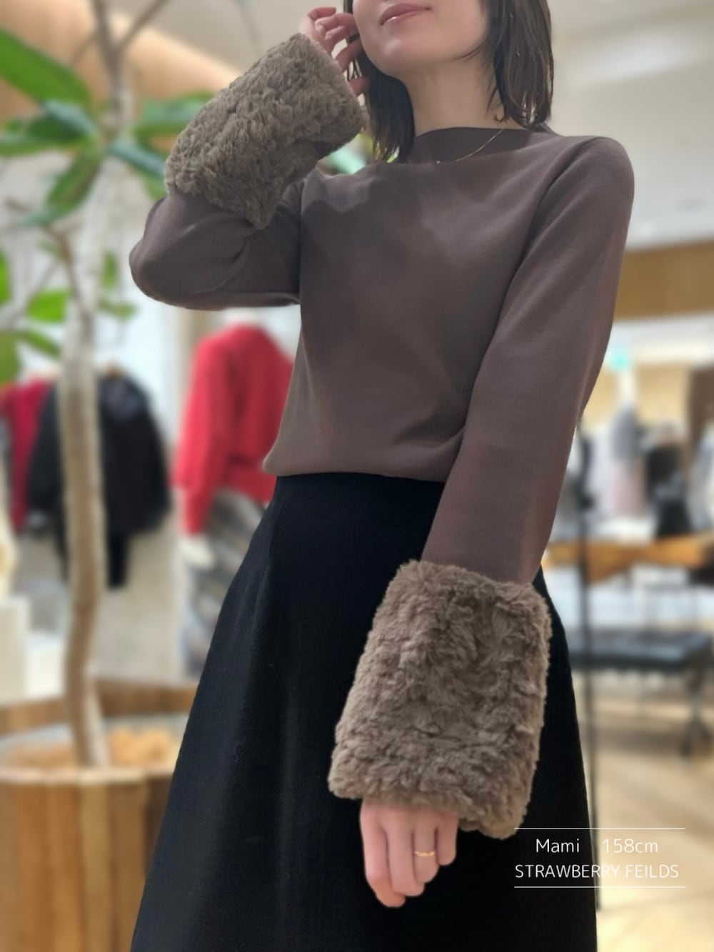 ブラウン系のニット/セーター、ブラック系のスカートを着用したレディースの秋コーディネートの1枚目の写真