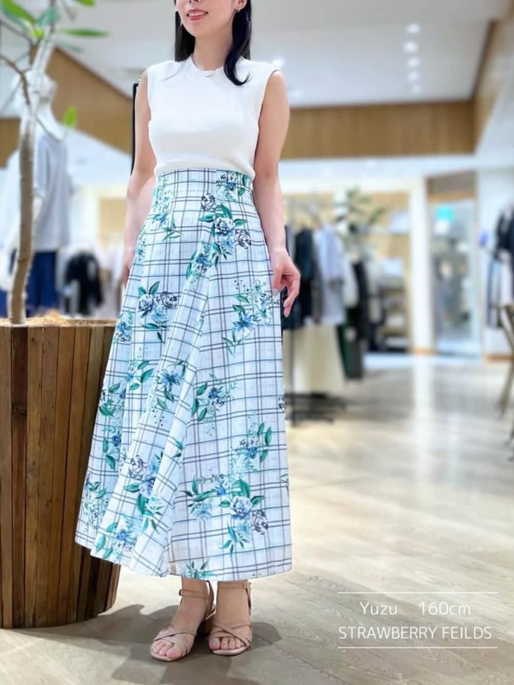 「なんばCITY店_YUZU、STRAWBERRY-FIELDS(STRAWBERRY-FIELDS)、ノースリーブニット、ホワイトニット、プリントスカート、セミマーメイドスカート、チェック×フラワー柄、清涼感コーデ、洗濯機OK、きれいめカジュアル、通勤スタイル、デートコーデ、お出かけコーデ、2025夏LOOKBOOK、大人フェミニンコーデ」｜「STRAWBERRY-FIELDSのソフトマーメイドプリントスカート（スカート、ブルー系）」を使った、STRAWBERRY-FIELDSさん（レディース・160cm）の夏コーディネートの1枚目の写真