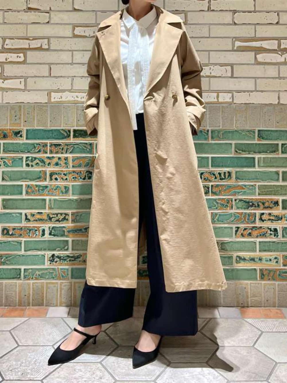 ベージュ系のトレンチコート、ホワイト系のシャツ/ブラウス、ブルー系のその他パンツを着用したレディースの冬コーディネートの1枚目の写真