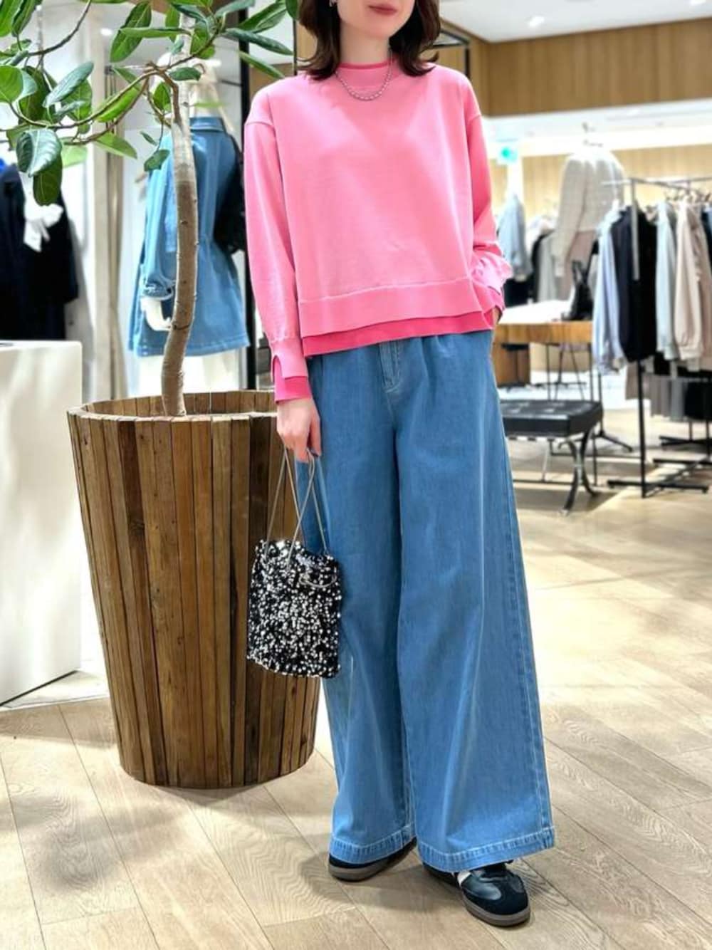 ブルー系のデニムパンツ、ピンク系のニット/セーターを着用したレディースの冬コーディネートの1枚目の写真