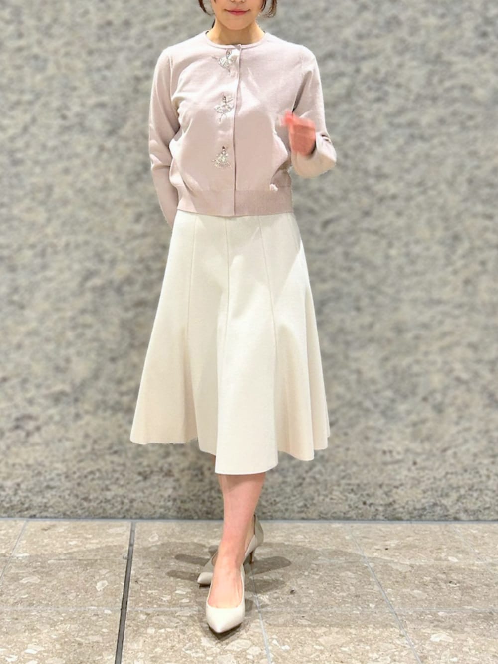 ピンク系のカーディガン/ボレロ、ベージュ系のスカートを着用したレディースの冬コーディネートの1枚目の写真