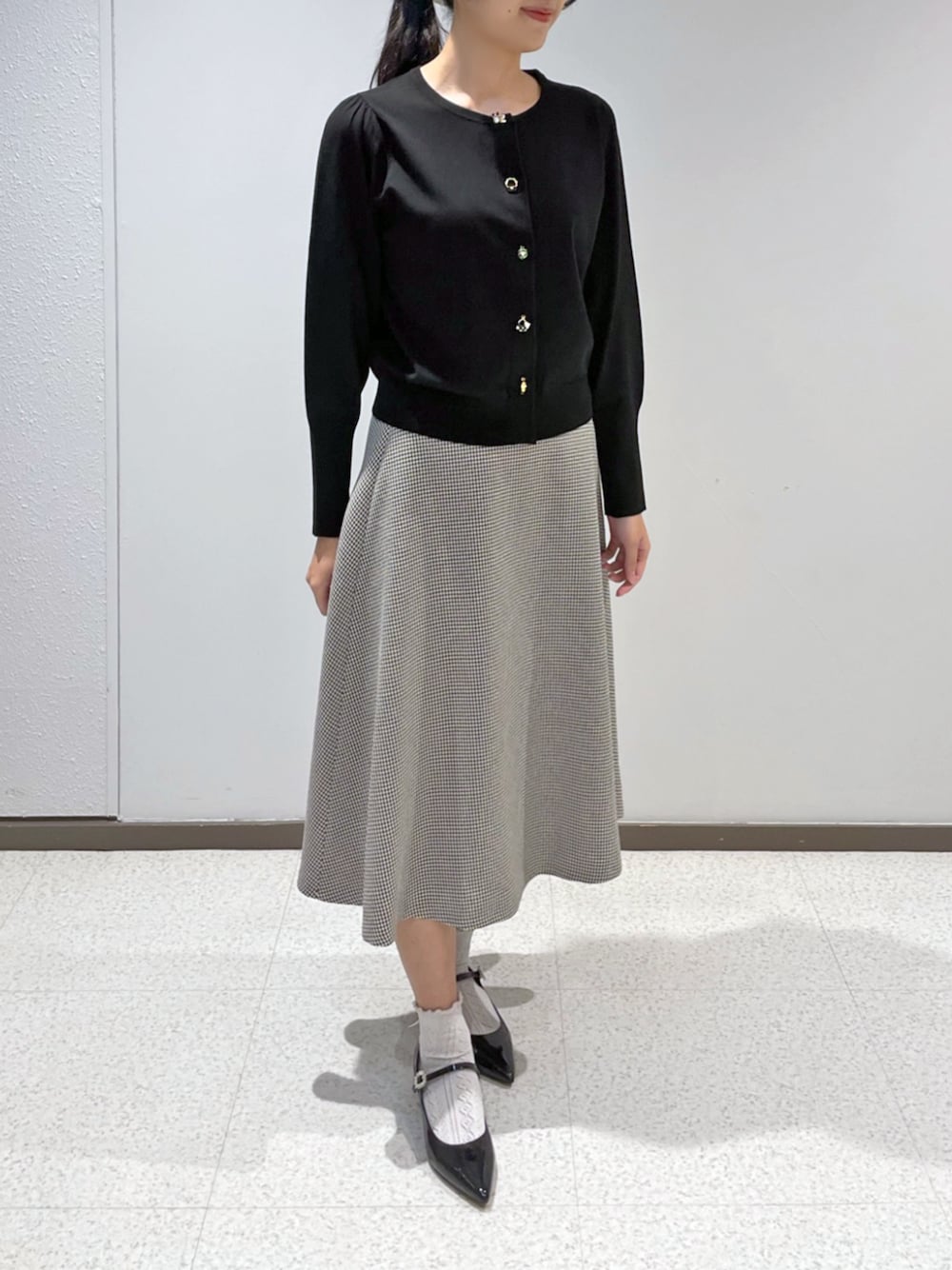 ホワイト系のスカートを着用したレディースの秋コーディネートの1枚目の写真