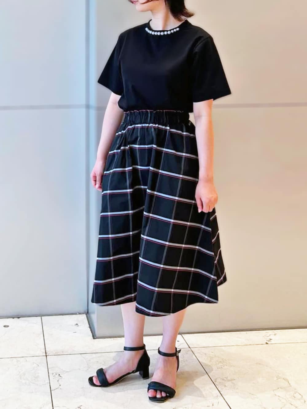 ブラック系のスカート、ブラック系のTシャツ/カットソーを着用したレディースの夏コーディネートの1枚目の写真
