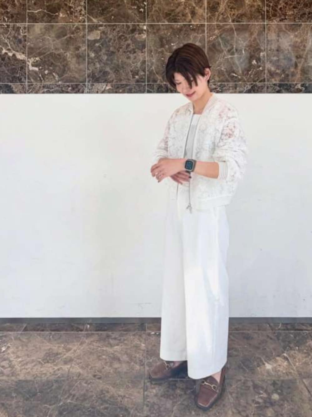 ホワイト系のブルゾン、ホワイト系のスラックスを着用したレディースの春コーディネートの1枚目の写真