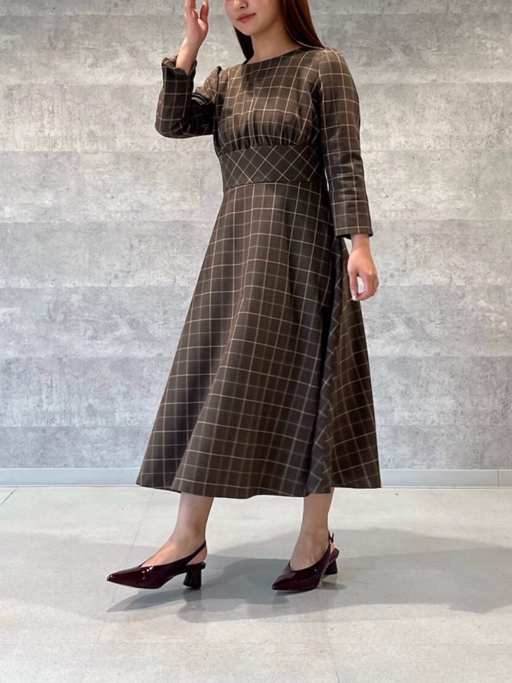 ブラウン系のワンピースを着用したレディースの秋コーディネートの1枚目の写真