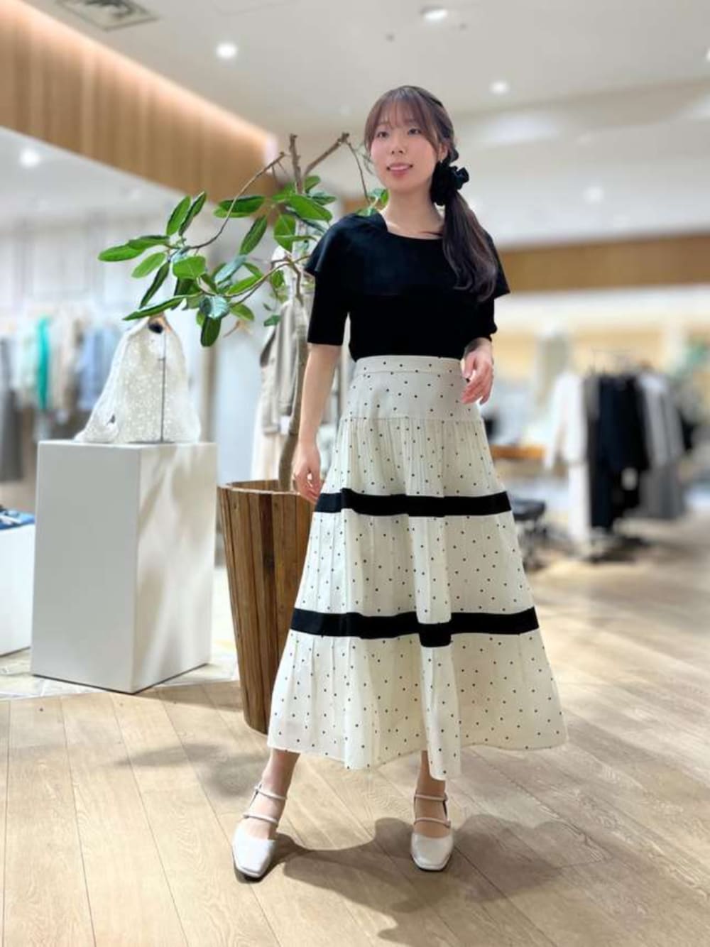 ホワイト系のスカート、ブラック系のニット/セーターを着用したレディースの春コーディネートの1枚目の写真