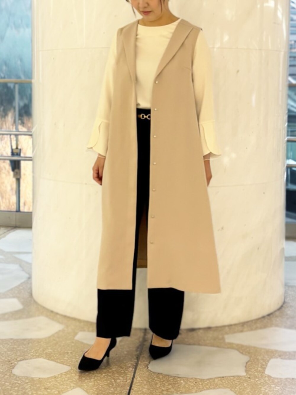 ホワイト系のシャツ/ブラウス、ベージュ系のジャンパースカート、ブラック系のスラックスを着用したレディースの冬コーディネートの1枚目の写真