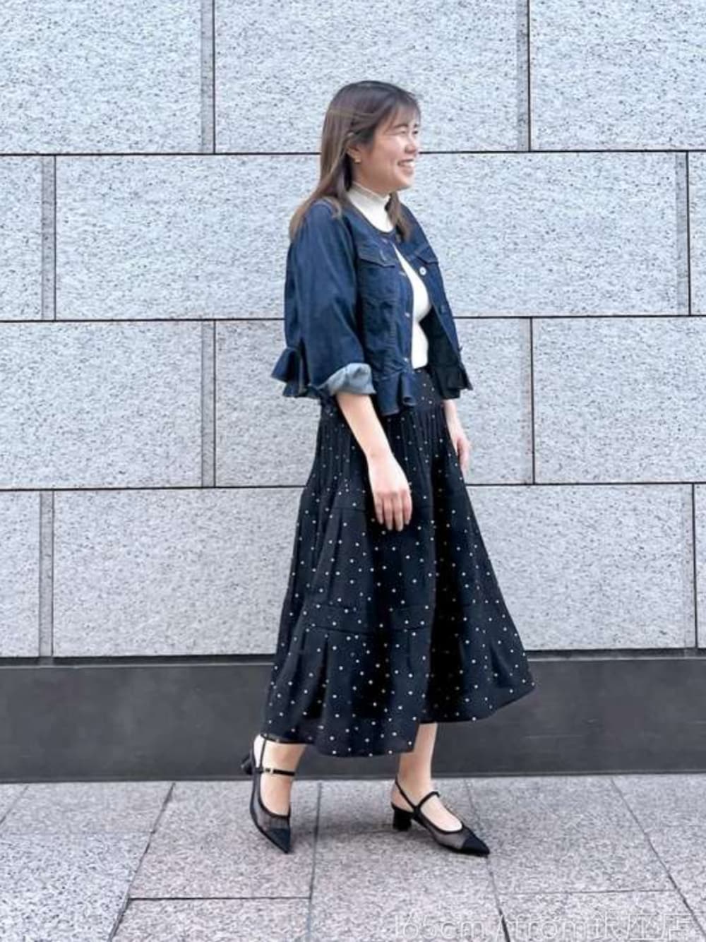 ブルー系のデニムジャケット、ブラック系のスカートを着用したレディースの春コーディネートの1枚目の写真