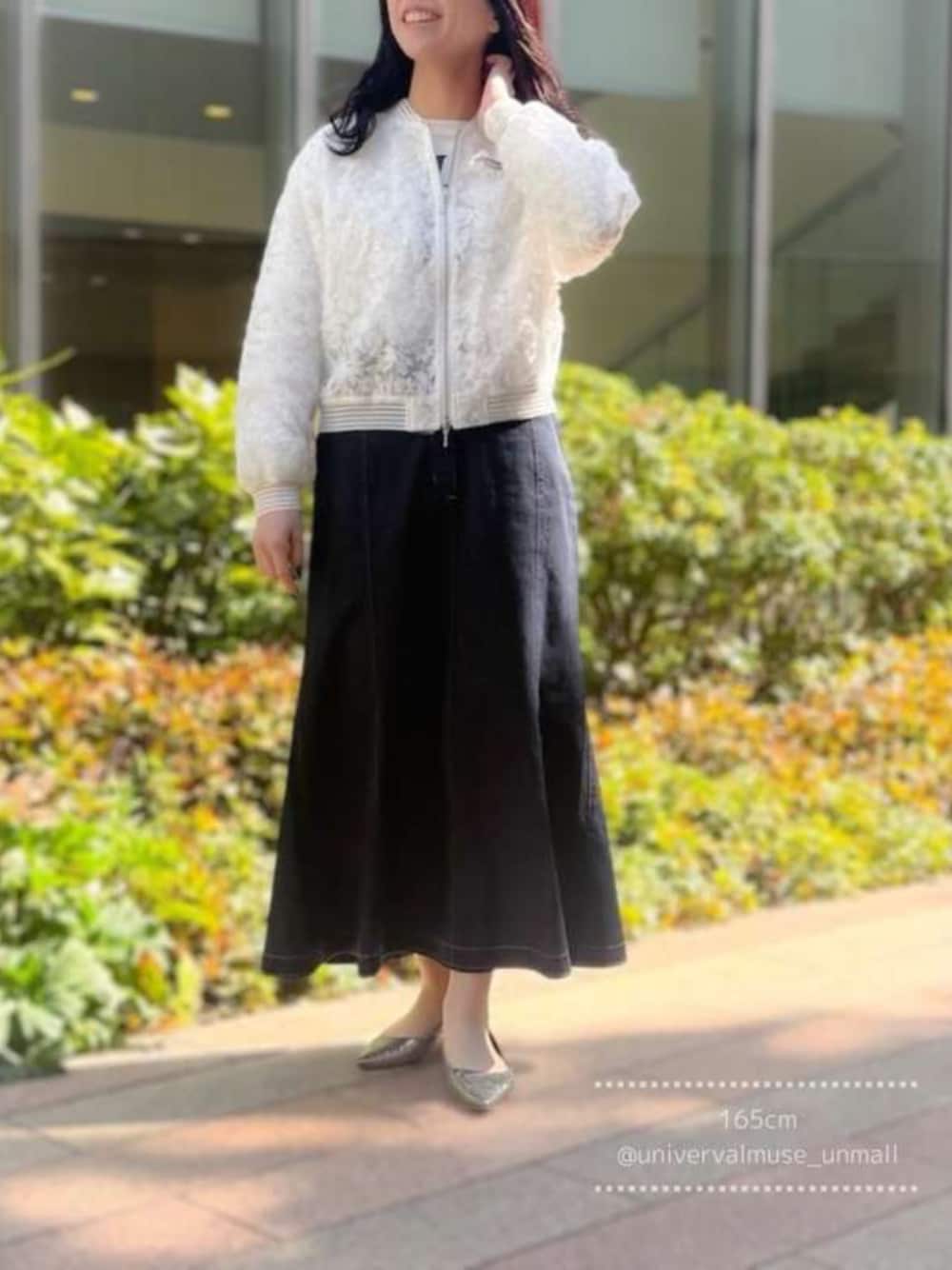 ホワイト系のブルゾン、ブルー系のデニムスカートを着用したレディースの春コーディネートの1枚目の写真