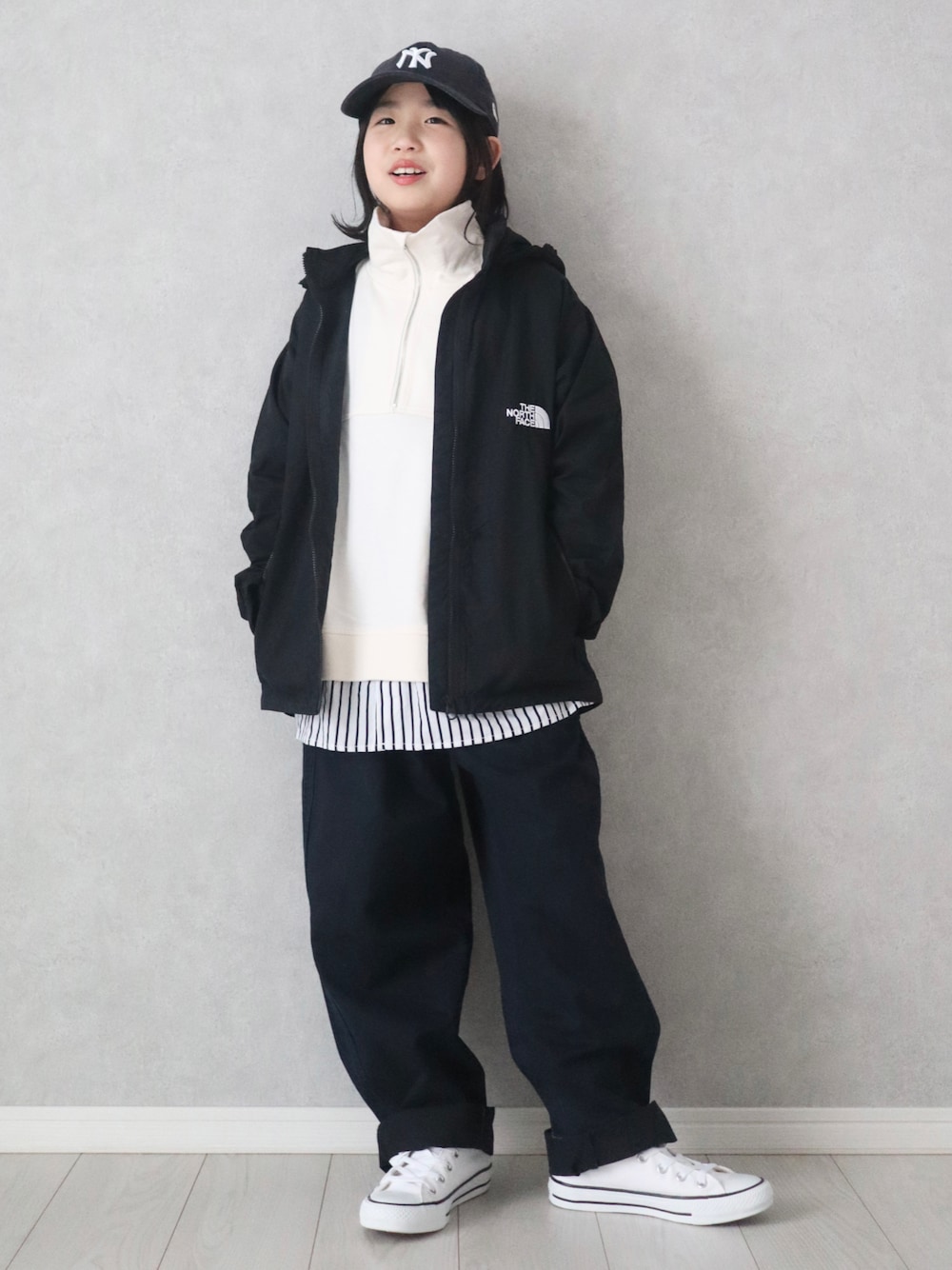 ベージュ系のチノパンツ、ブラック系のブルゾン、ホワイト系のスウェットを着用したキッズの冬コーディネートの1枚目の写真