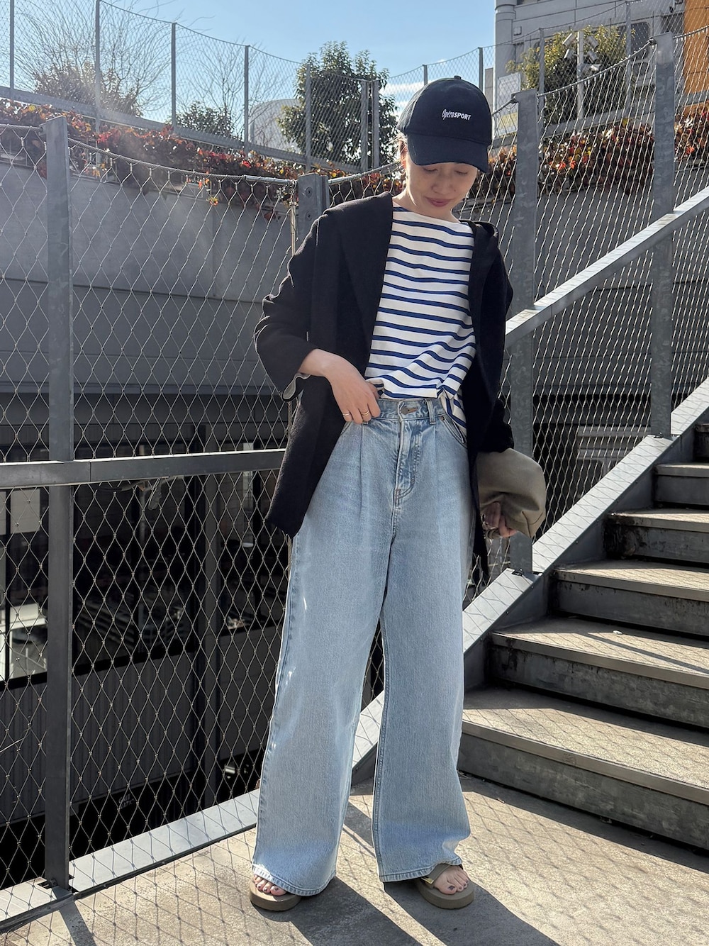 ブルー系のデニムパンツ、ブルー系のTシャツ/カットソー、ブラック系のカーディガン/ボレロを着用したレディースの春コーディネートの1枚目の写真
