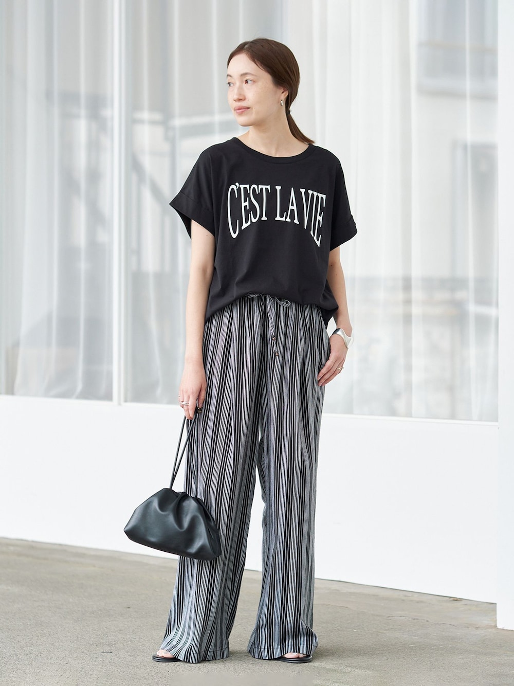 ブラック系のその他パンツ、ブラック系のTシャツ/カットソー、ブラック系のクラッチバッグを着用したレディースの夏コーディネートの1枚目の写真