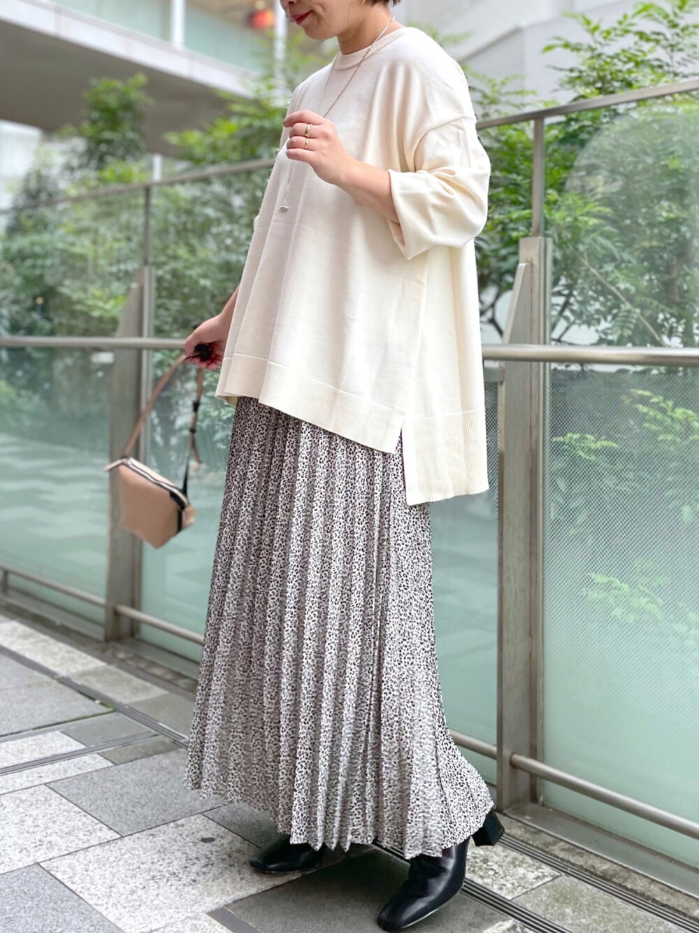 ベージュ系のトートバッグ、ホワイト系のワンピース、ブラック系のブーツを着用したレディースの秋コーディネートの1枚目の写真