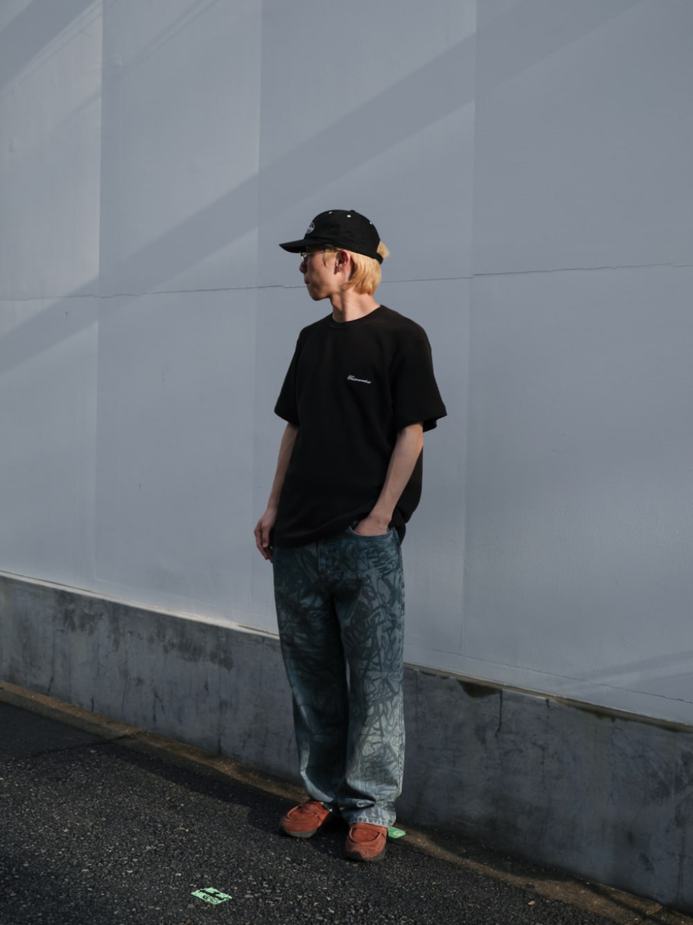 ブラック系のTシャツ/カットソー、ブルー系のデニムパンツ、ブラック系のキャップを着用したメンズの夏コーディネートの1枚目の写真