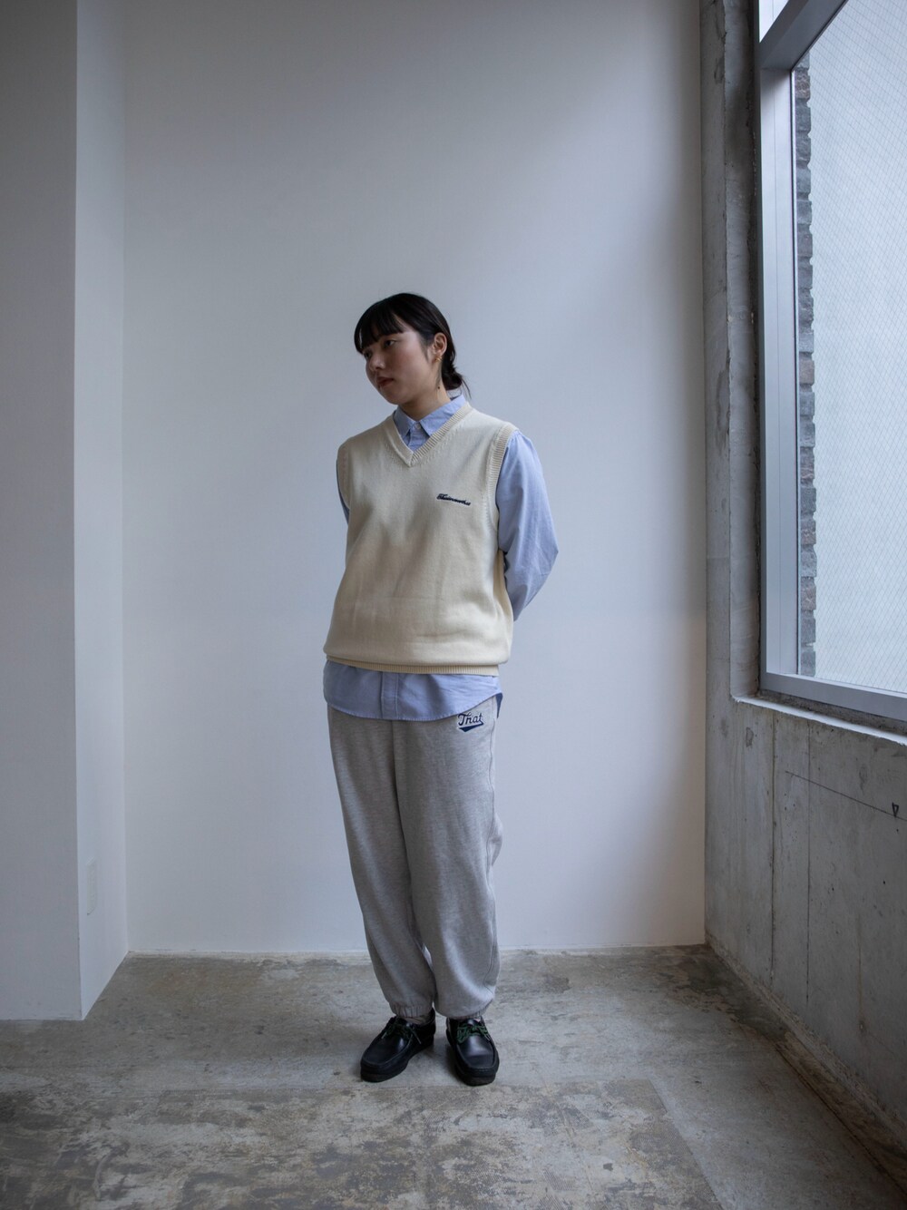 ホワイト系のベスト、ブルー系のシャツ/ブラウス、グレー系のスウェットパンツを着用したレディースの春コーディネートの1枚目の写真