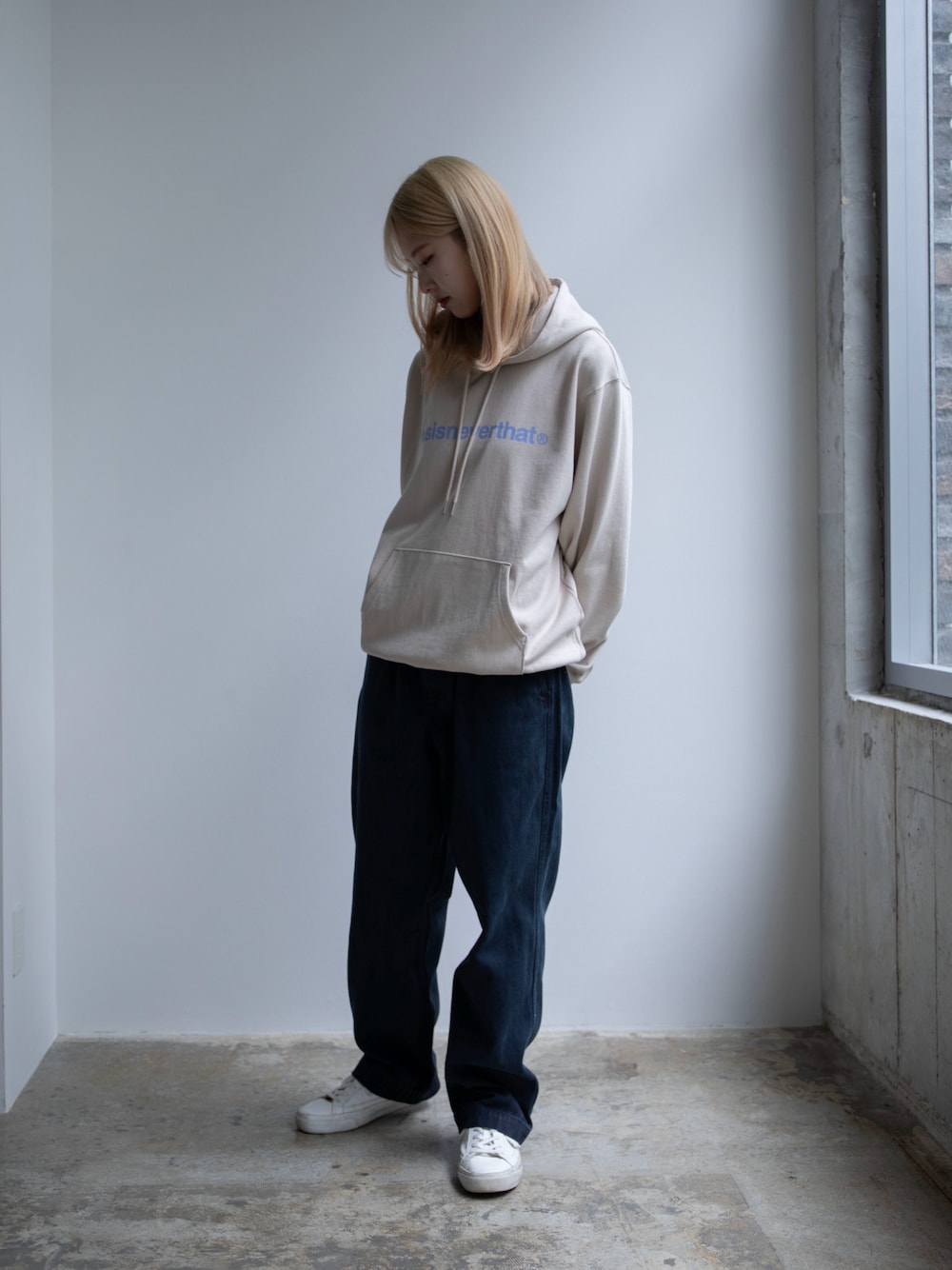 ベージュ系のパーカー、ブルー系のその他パンツを着用したレディースの春コーディネートの1枚目の写真