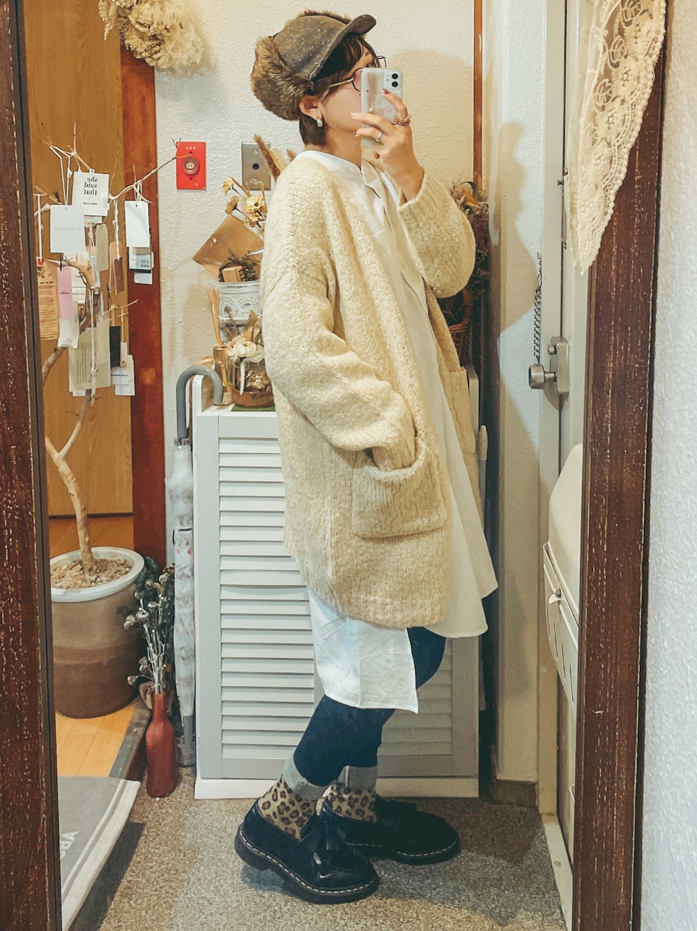 ホワイト系のシャツ/ブラウス、ブルー系のデニムパンツ、ベージュ系のカーディガン/ボレロを着用したレディースの秋コーディネートの1枚目の写真