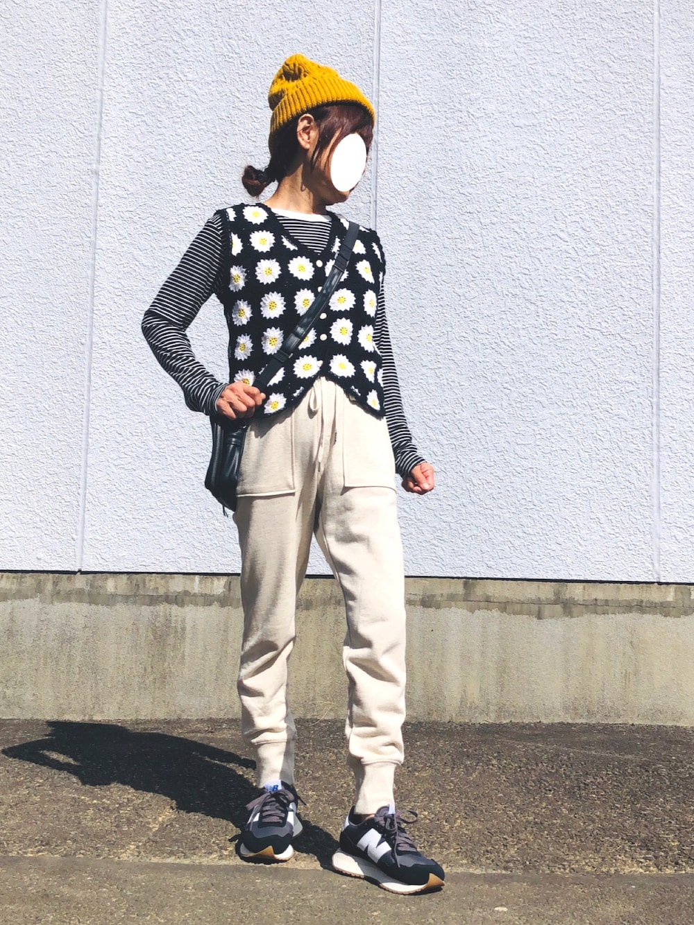 ブラック系のTシャツ/カットソー、ブラック系のベスト、ホワイト系のスウェットパンツを着用したレディースの秋コーディネートの1枚目の写真