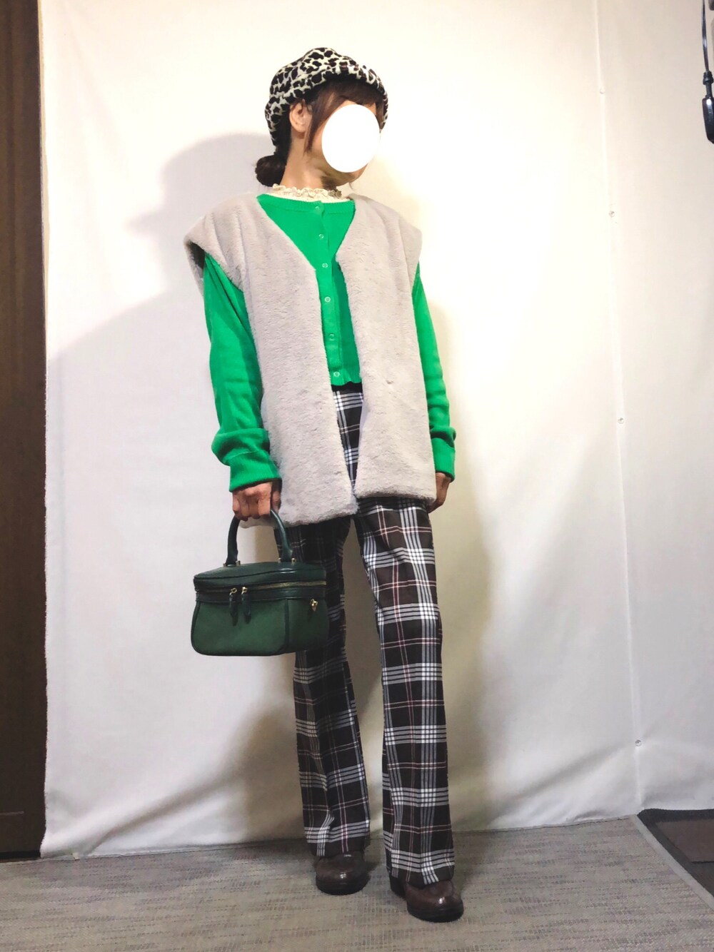 グレー系のベスト、グリーン系のカーディガン/ボレロ、ベージュ系のTシャツ/カットソーを着用したレディースの秋コーディネートの1枚目の写真