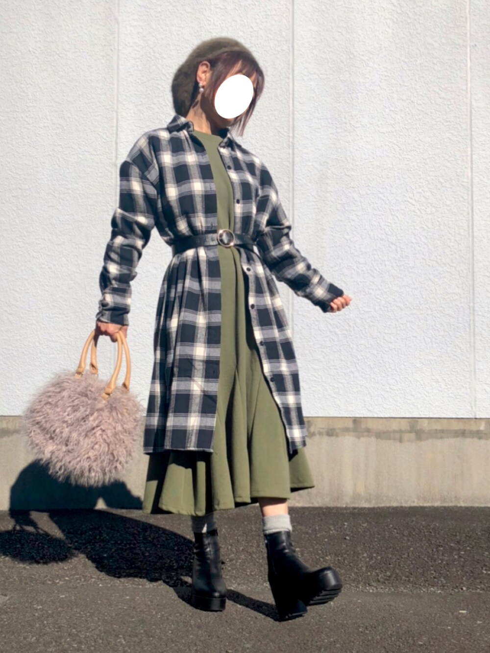 グリーン系のワンピース、ブラック系のシャツワンピース、ブラック系のブーツを着用したレディースの冬コーディネートの1枚目の写真