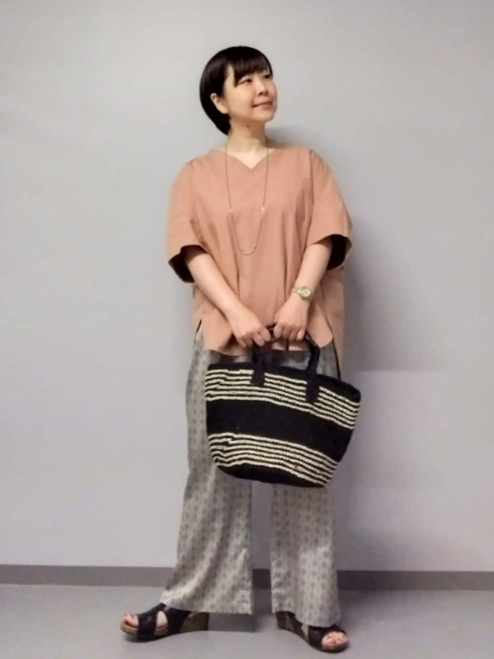 ベージュ系のその他パンツ、ブラック系のかごバッグ、ピンク系のシャツ/ブラウスを着用したレディースの夏コーディネートの1枚目の写真