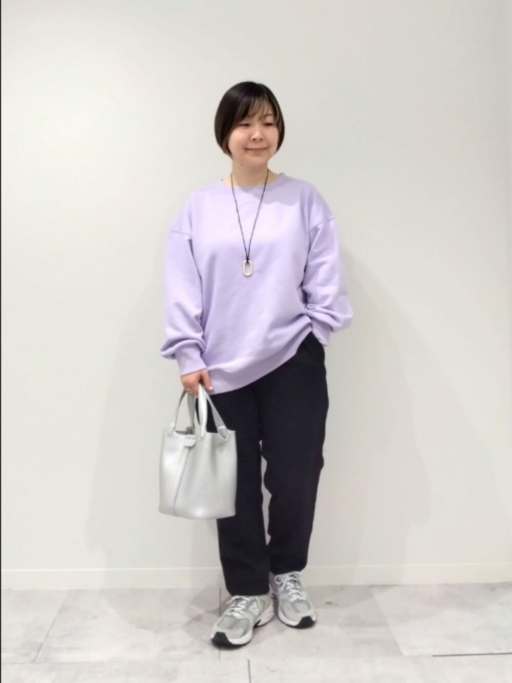 パープル系のスウェット、シルバー系のトートバッグ、ブラック系のその他パンツを着用したレディースの春コーディネートの1枚目の写真