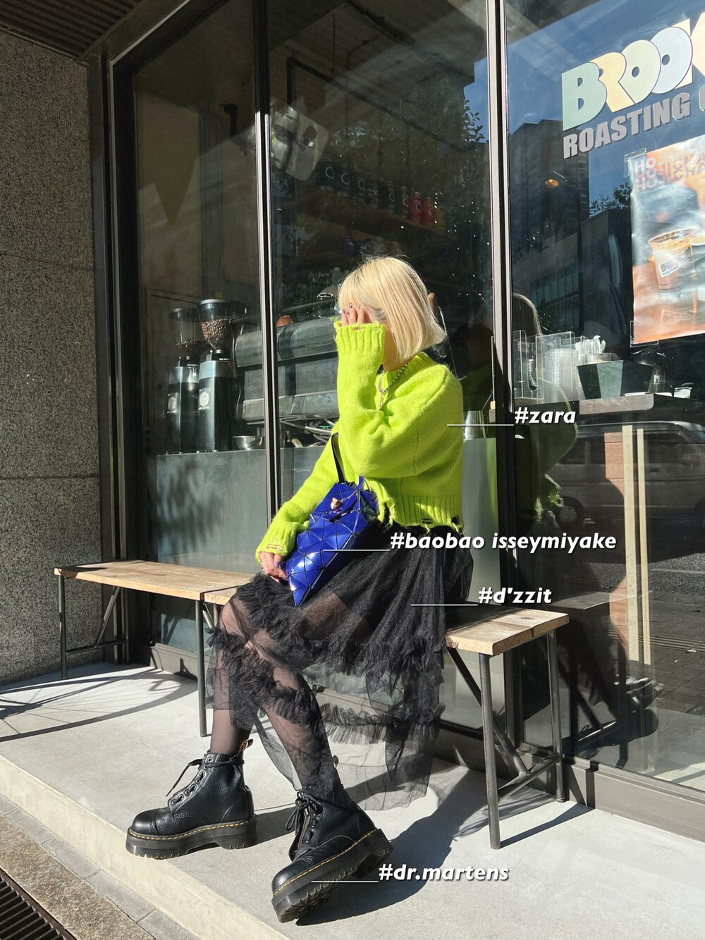ブルー系のトートバッグ、ブラック系のブーツを着用したレディースの秋コーディネートの1枚目の写真