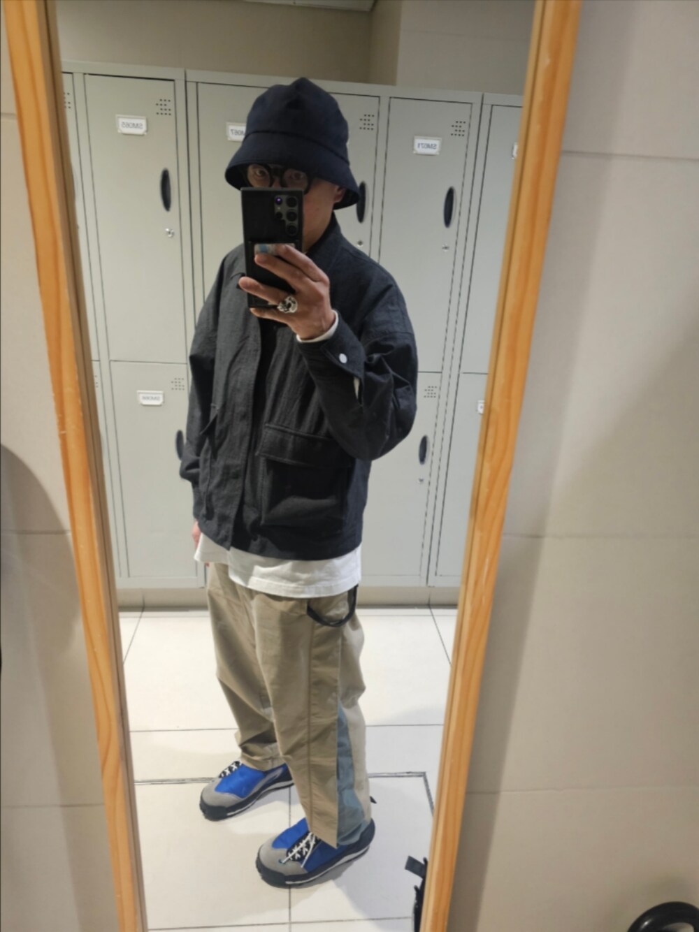 グレー系のジャケット/アウター、ゴールド系のチノパンツ、ブルー系のスニーカーを着用したメンズの冬コーディネートの1枚目の写真