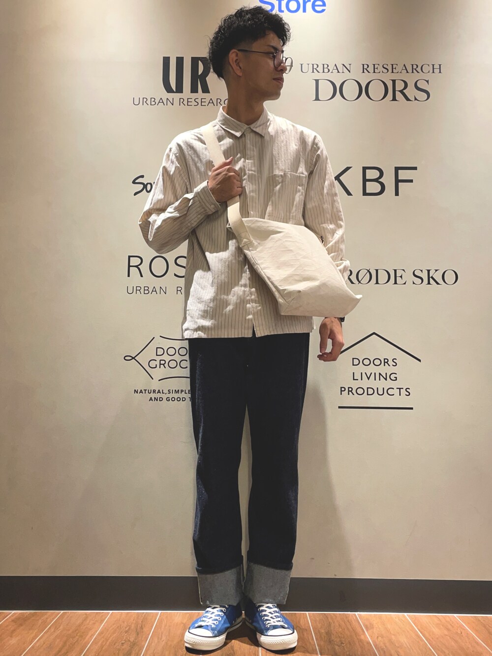 ホワイト系のシャツ/ブラウス、ホワイト系のショルダーバッグ、ブルー系のデニムパンツを着用したメンズの秋コーディネートの1枚目の写真